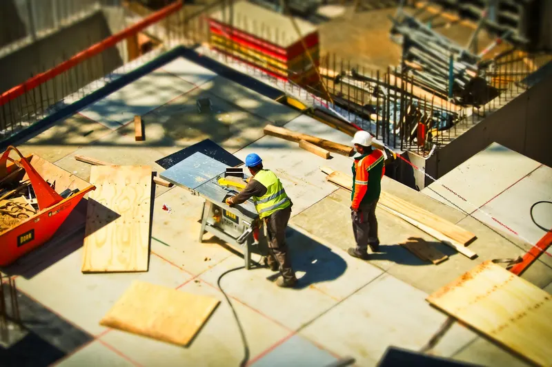 Construction workers laying a floor on a building site